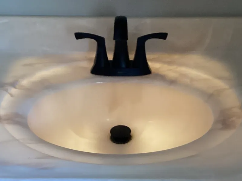The same bathroom sink with a new matte black faucet and matching drain
