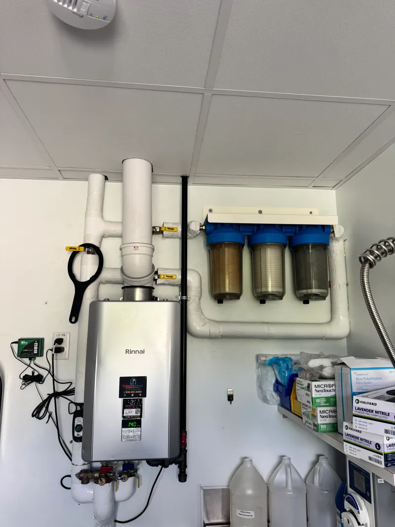 Rinnai tankless water heater and a three-stage whole-building sediment filter in a clean commercial utility room
