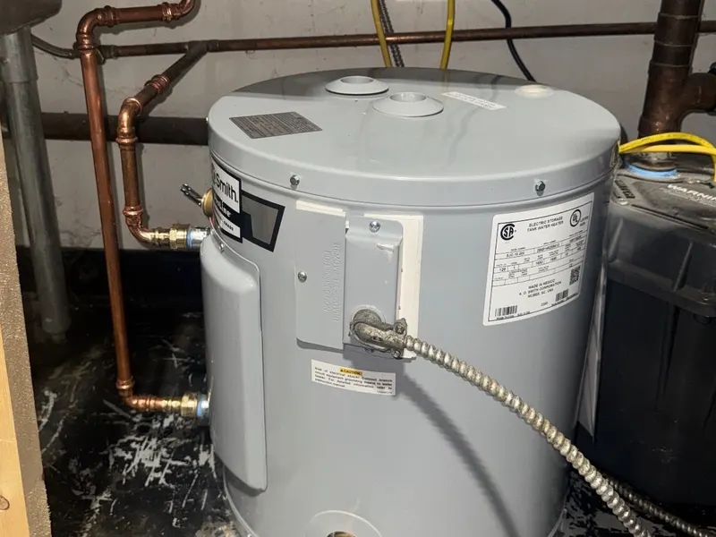 New compact electric water heater in the same corner, with new copper water lines and a new electrical connection